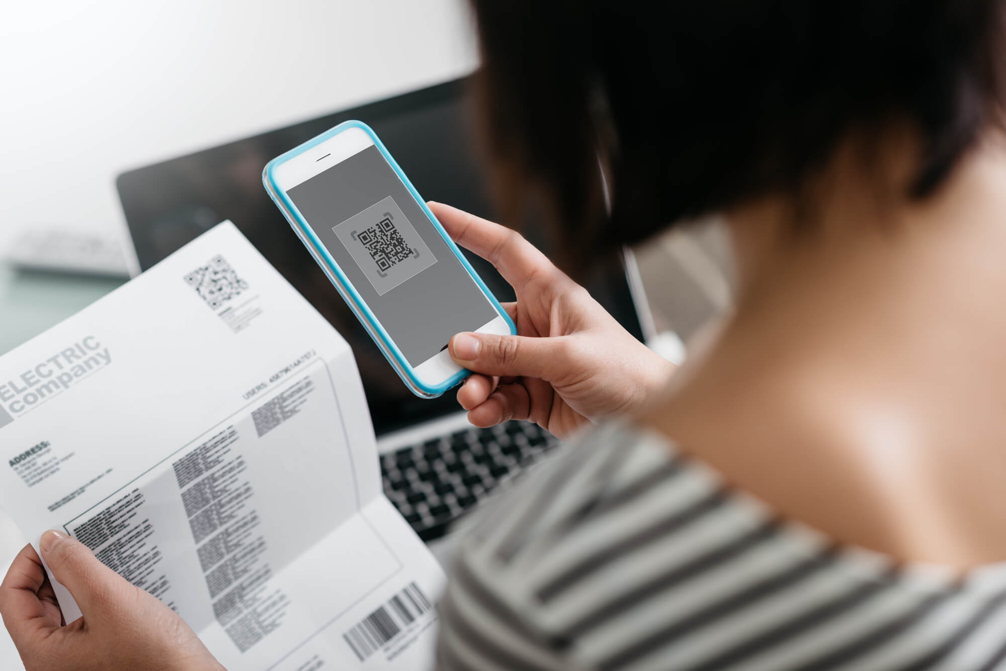 Woman paying electricity bill with her smartphone